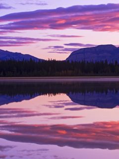 Reflet serein du coucher de soleil sur les montagnes