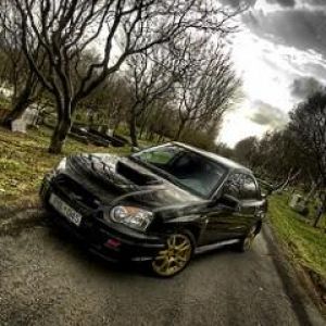 Voiture de sport noire sur une route pittoresque