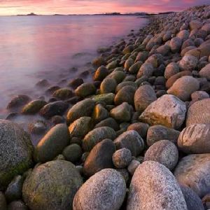 Coucher de soleil serein sur une côte rocheuse