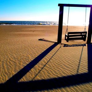 Balançoire sur la plage au coucher du soleil