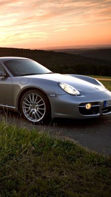 Voiture de sport argentée au coucher de soleil